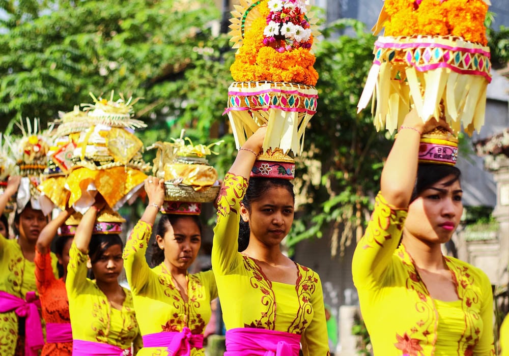 Women and girls carry offerings during a Melasti procession on Bali