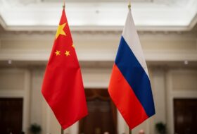 Chinese and Russian flags in a formal hall, symbolizing deepened bilateral ties