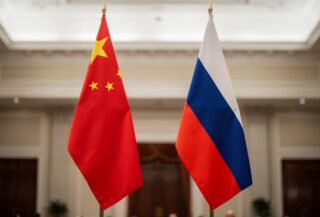 Chinese and Russian flags in a formal hall, symbolizing deepened bilateral ties