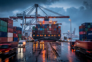 Container ships and cranes at Laem Chabang port, Thailand, at dusk
