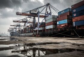 Busy container port in Mumbai, India, under an overcast sky