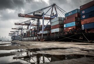 Busy container port in Mumbai, India, under an overcast sky