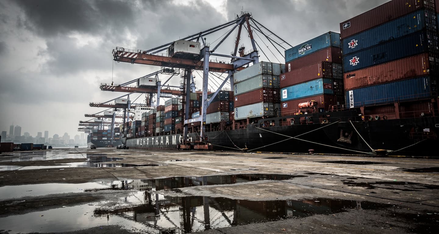 Busy container port in Mumbai, India, under an overcast sky