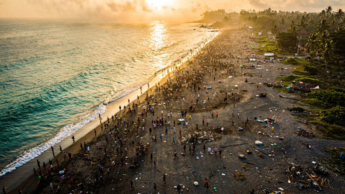 Crowded beach in Bali at sunset, with environmental strain visible