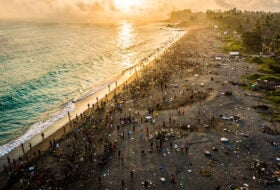 Crowded beach in Bali at sunset, with environmental strain visible