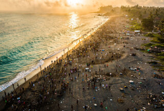 Crowded beach in Bali at sunset, with environmental strain visible