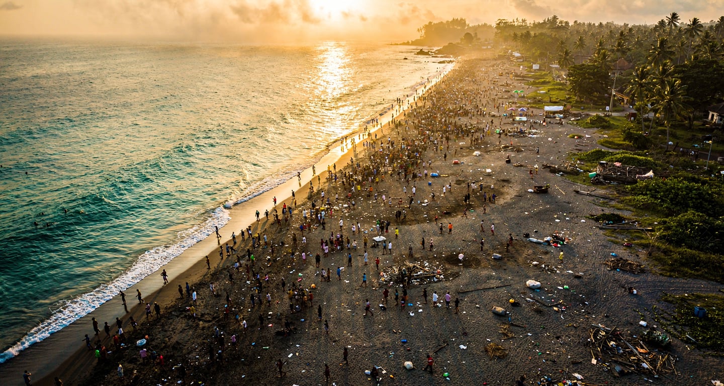 Crowded beach in Bali at sunset, with environmental strain visible