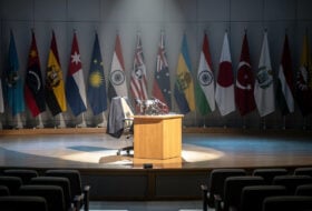 Defense Secretary Hegseth at a podium in Singapore with Indo-Pacific flags