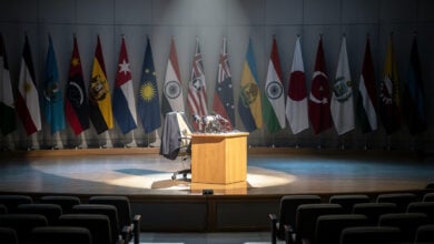 Defense Secretary Hegseth at a podium in Singapore with Indo-Pacific flags