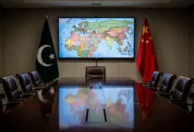 Diplomatic meeting room with Pakistani and Chinese flags, Middle East map on screen