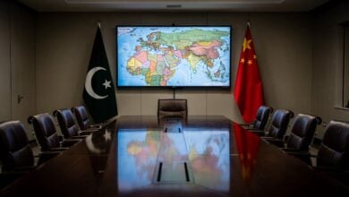Diplomatic meeting room with Pakistani and Chinese flags, Middle East map on screen