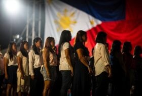 Diverse women on a stage under bright lights, representing Filipino identity