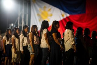Diverse women on a stage under bright lights, representing Filipino identity