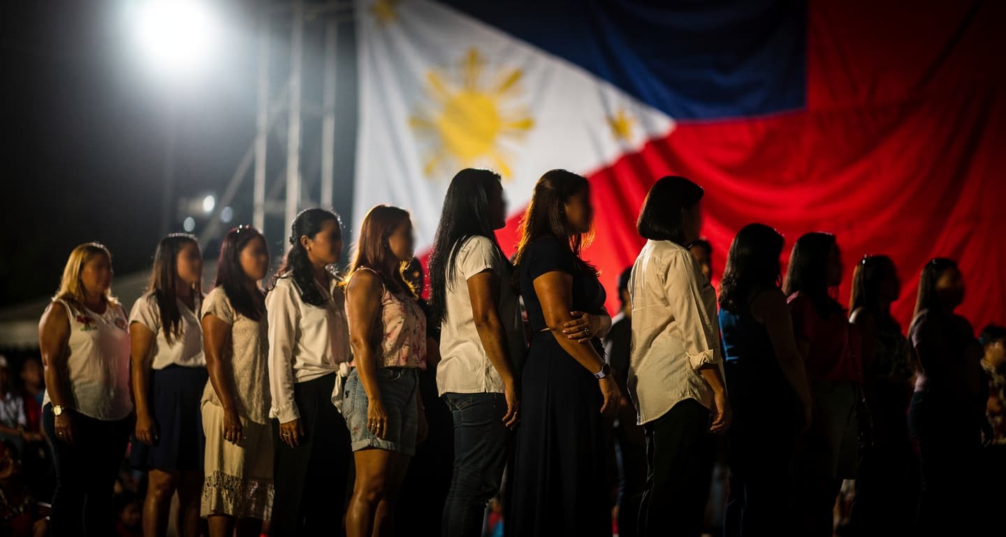 Diverse women on a stage under bright lights, representing Filipino identity