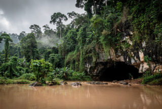 Flooded entrance of a karst cave in rural Laos jungle