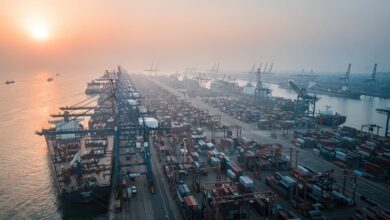 Industrial port at Mumbai, India, with container ships and cranes at dawn