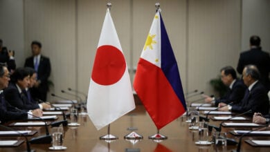 Japanese and Philippine flags at formal Tokyo summit table, diplomatic setting