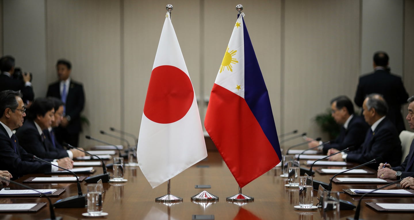 Japanese and Philippine flags at formal Tokyo summit table, diplomatic setting