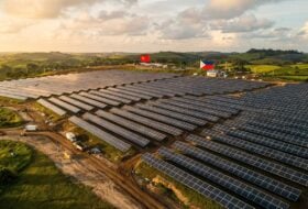 Solar panel field construction in rural Philippines, with flags in background
