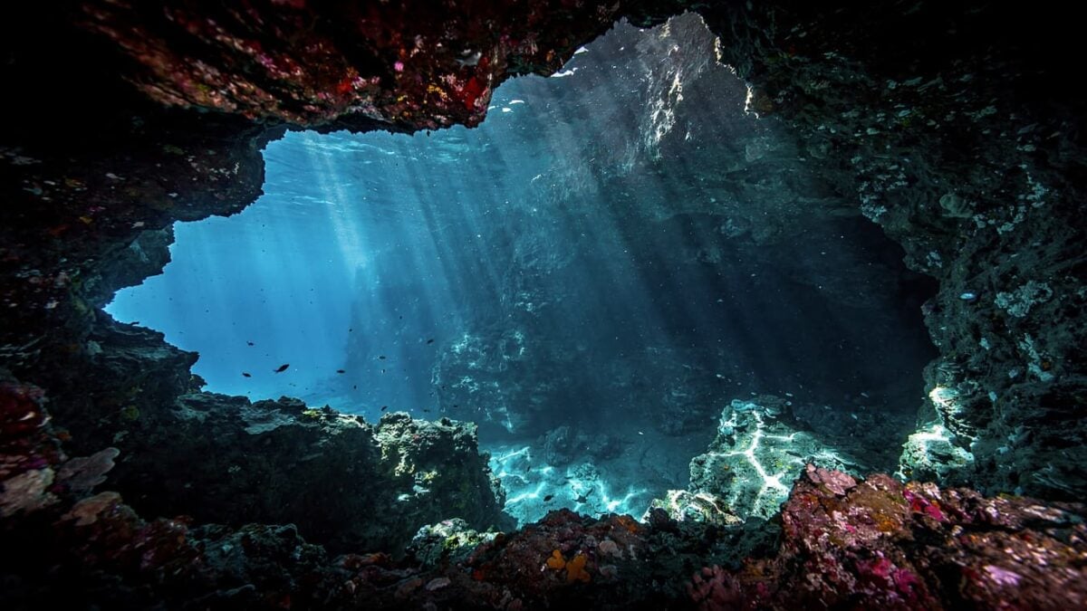 Underwater cave entrance in Vaavu Atoll, Maldives, with dramatic lighting