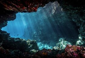Underwater cave entrance in Vaavu Atoll, Maldives, with dramatic lighting