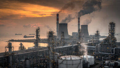 Coal and oil refinery infrastructure along Southeast Asian coast at dusk