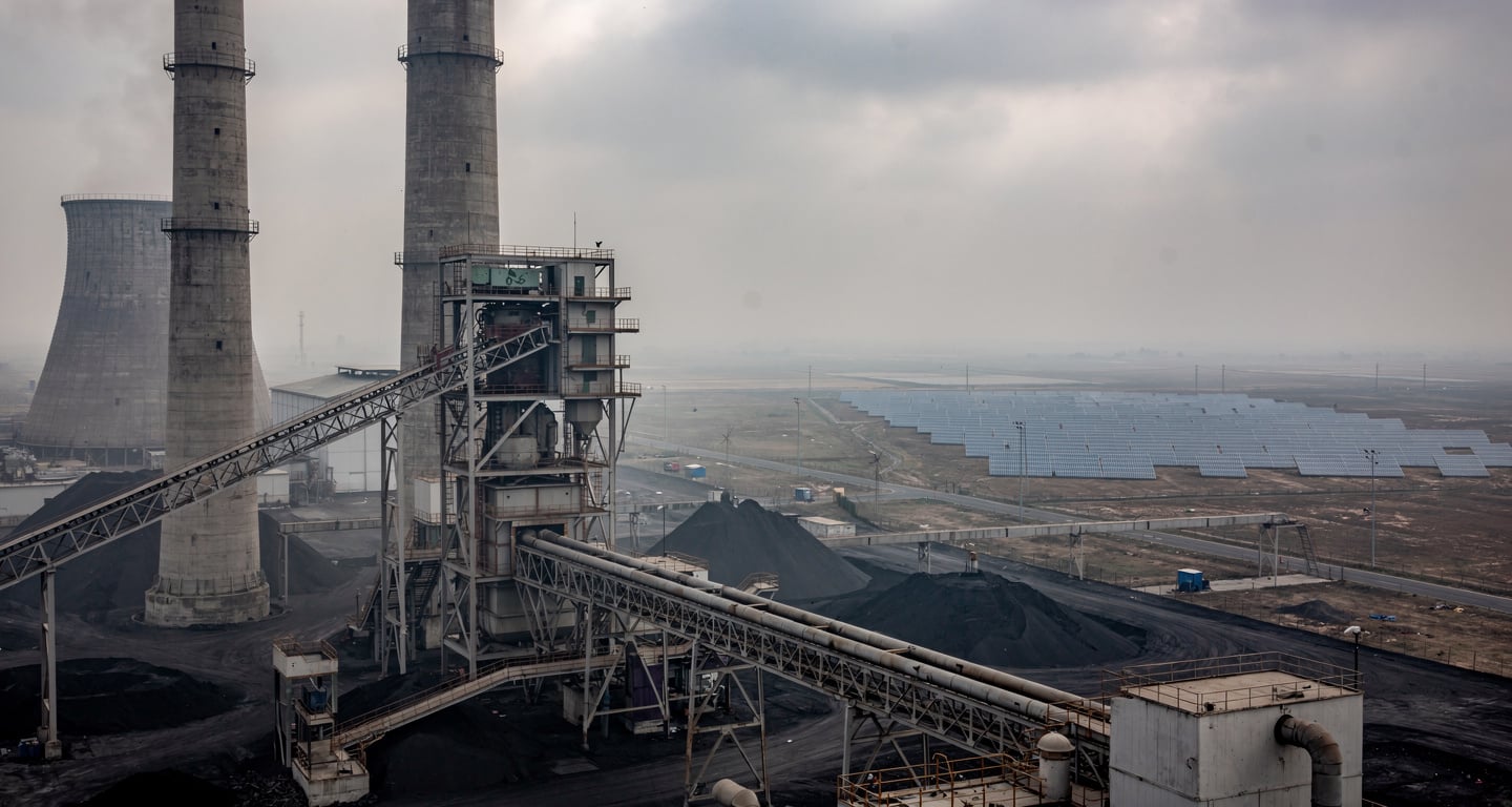 Coal power plant with solar panels in background, northern India industrial landscape