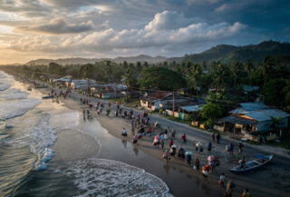 Coastal residents evacuating inland from Mindanao beach at dawn