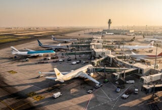 Commercial aircraft parked at international airport hub, Middle East region, golden hour lighting