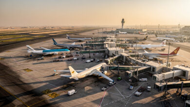 Commercial aircraft parked at international airport hub, Middle East region, golden hour lighting