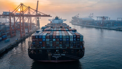 Container ship loaded with electric vehicles at Southeast Asian port, dawn light