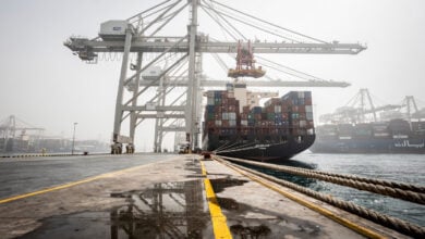Container ship at Gulf port terminal with industrial cranes and stacked cargo containers