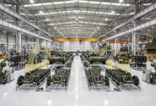 Defense manufacturing assembly line in South Korea with military vehicles under industrial lighting