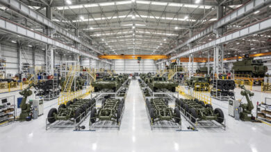 Defense manufacturing assembly line in South Korea with military vehicles under industrial lighting