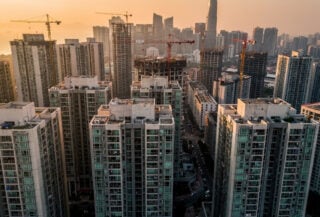 Dense high-rise residential towers in Asian city skyline at golden hour