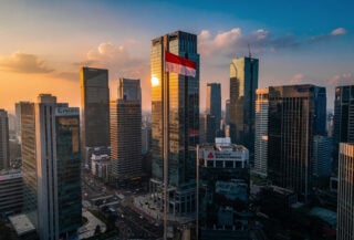 Jakarta financial district skyline at dusk with banking headquarters and Indonesian flag