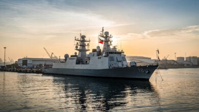 Modern military frigate docked at Manila naval base with Philippine flag