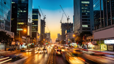New Delhi financial district at dusk with office towers and construction cranes