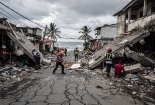 Rescue workers searching through collapsed buildings in Mindanao coastal town after earthquake