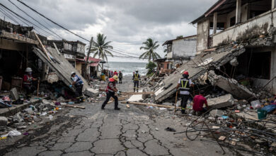 Rescue workers searching through collapsed buildings in Mindanao coastal town after earthquake