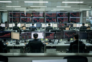 Seoul trading floor with red market indices on screens during market downturn