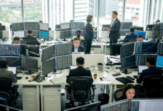 Singapore financial district trading floor with currency screens and Asian exchange rates displayed