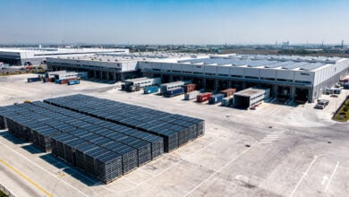 Solar panel manufacturing facility with stacked modules and export containers