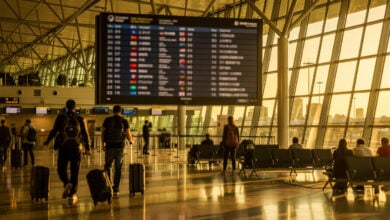 Sydney airport departure board showing Asian destinations, modern terminal with travellers
