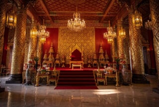 Thai royal palace formal ceremonial hall with ornate gold decoration and empty throne