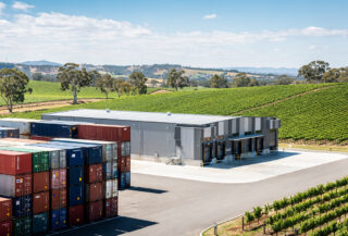 Wine export facility with shipping containers, rural Australia vineyard landscape