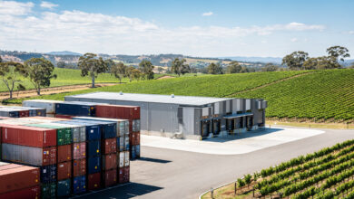 Wine export facility with shipping containers, rural Australia vineyard landscape