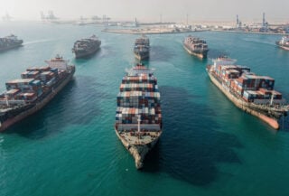 Aerial view of container ships anchored in Persian Gulf with visible hull fouling