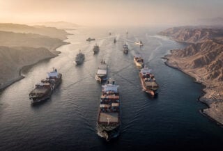 Aerial view of Strait of Hormuz with container ships and tankers in narrow waterway