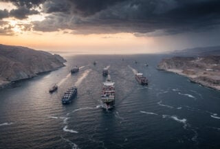 Aerial view of Strait of Hormuz with tanker ships transiting narrow waterway between Iran and Oman